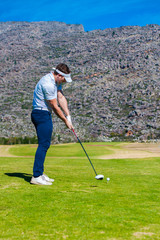 Fototapeta premium view of a golfer teeing off from a golf tee