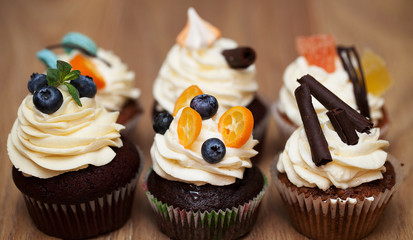 Many different cakes standing on a wooden table