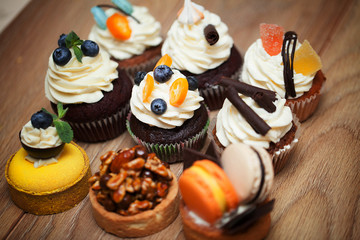 Nine different cakes standing on a wooden table