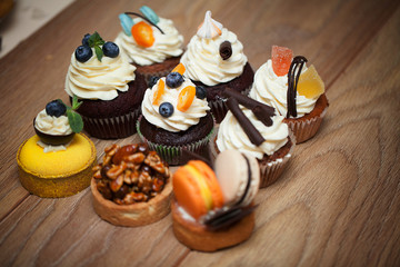 Nine different cakes standing on a wooden table