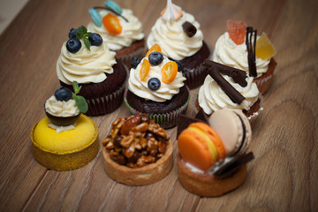 Nine different cakes standing on a wooden table