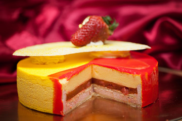 A piece of mango cheese cake on white background as a studio shot