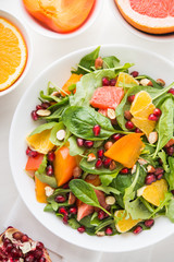 Fresh salad with fruits and greens on white background top view. Healthy food.