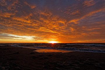 Fototapeta na wymiar Orange sunset on the beach. Baltic Sea.