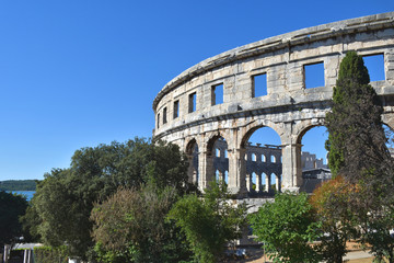 Fototapeta premium Römisches Amphitheater in Pula/Kroatien (Istria) vor blauem Himmel und Meer