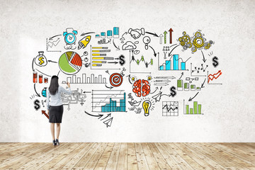 Businesswoman near wall with start up sketch