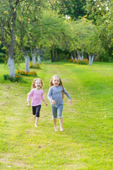 Fototapeta premium Two cute girls playing in the par
