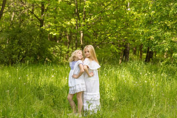 Two young girls relaxing on nature in summer