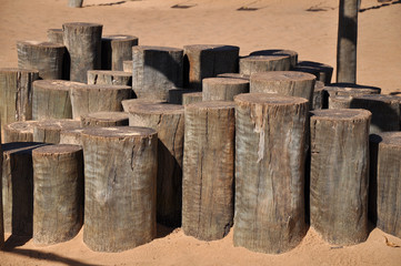 Naklejka premium Wooden trunks nailed in the sand at amusement park