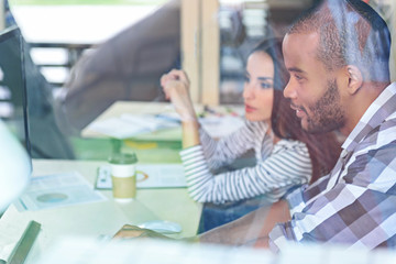 Clever man and woman using computer at work