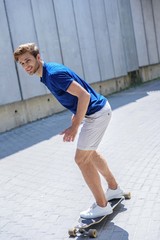 Joyful guy riding skate outdoors