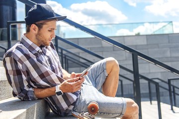 Skillful male skater using smartphone © Yakobchuk Olena
