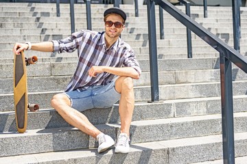 Carefree male skater sitting on stairs © Yakobchuk Olena
