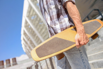 Cheerful guy holding his skate