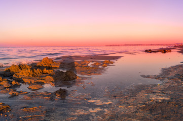 Fototapeta na wymiar Mare, spiaggia al tramonto con cielo rosso. Sea, beach at sunset with red sky