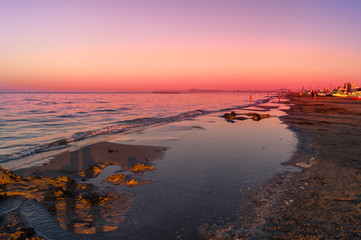 Fototapeta na wymiar Mare, spiaggia al tramonto con cielo rosso. Sea, beach at sunset with red sky