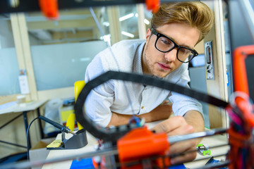 Skillful young engineer constructing 3d printing