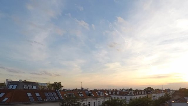 sunset sky and clouds over city skyline - time lapse