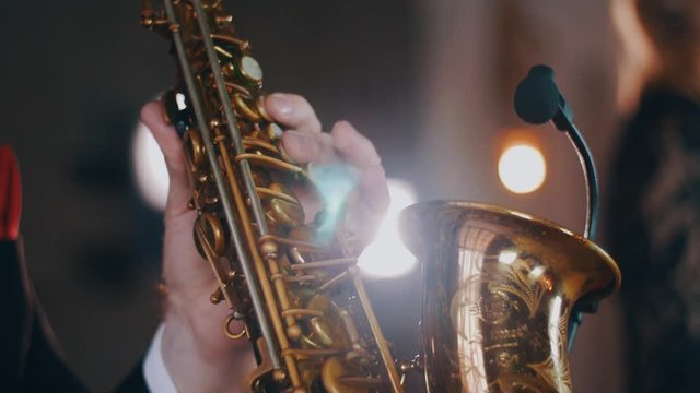 Saxophonist in dinner jacket perform on stage. Spotlight. Golden saxophone. Jazz. Musician