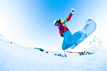 Fototapeta na wymiar girl snowboarder having great fun jumping