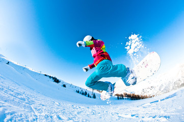 Naklejka na ściany i meble girl snowboarder having great fun jumping
