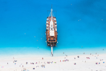 Fototapeta na wymiar large sail cruise ship anchored at white sand beach, seen from above