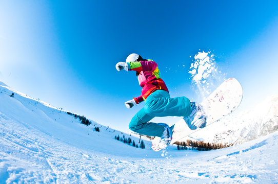 girl snowboarder having great fun jumping