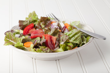 Fresh organic Italian salad on white wood