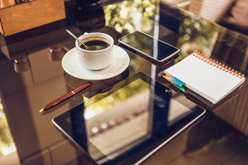 Workplace. Phone, tablet and notepad on the table