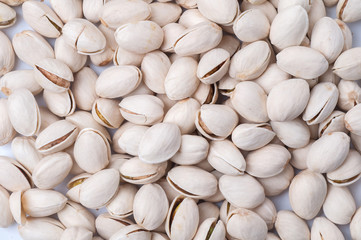 Roasted and salted pistachios in shell on white background