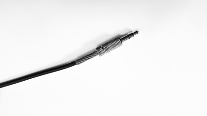 Close up of audio jack with black cable on white background isolated.