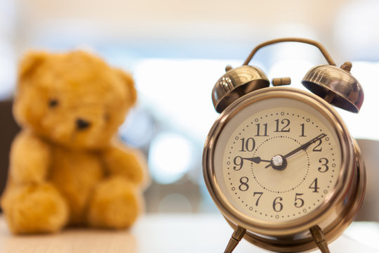 Retro Teddy Bear toy alone with alam clock.
