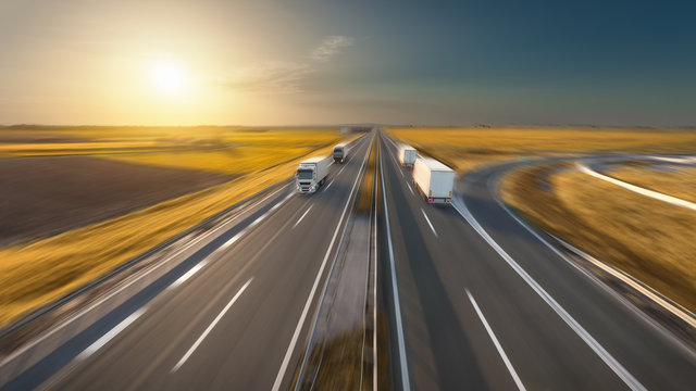 Speed concept with trucks on the highway at idyllic sunset