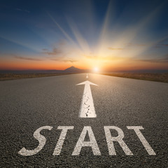 Success concept on an open road with start text at sunset