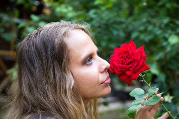Fototapeta premium Portrait of a beautiful girl with a red rose