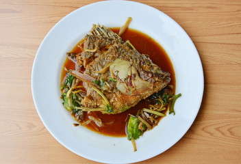 deep fried mango fish head dressing ginger and soy sauce on dish