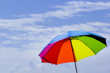 Fototapeta na wymiar Beautiful Rainbow umbrella on bright sky background.