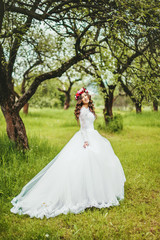 Obraz na płótnie Canvas Bride in white dress in a garden