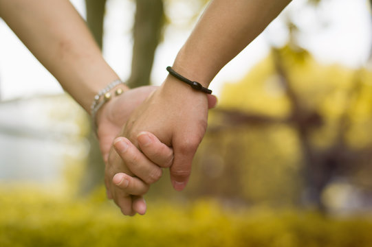 Young couple in love walking in the park holding hands , selective focus , copy space , filter color effect