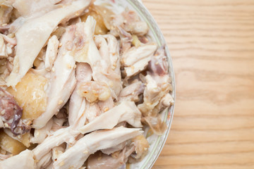 dish of shredded boiled chicken on wood table with copy space