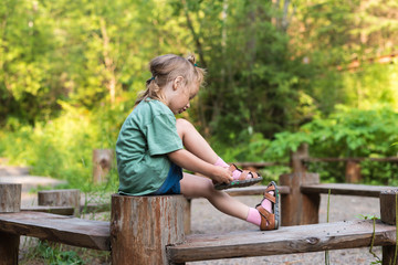 Little girl putting her sandal on