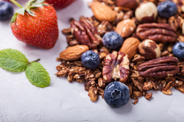 Granola with nuts,Goji berries, honey,and berries,scattered on the table.Healthy dry Breakfast.selective focus.