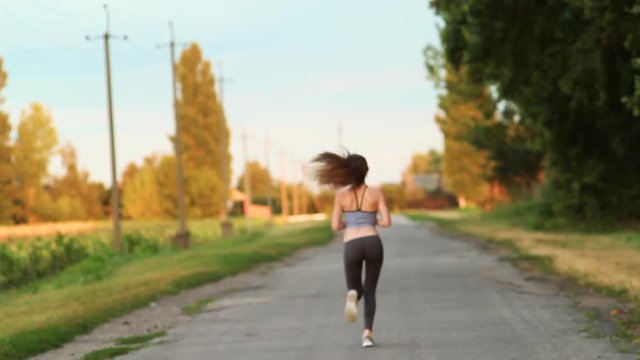 Morning Running. Girl Athlete Runs Down the Road in the Morning. Sport.