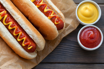 Barbecue Grilled Hot Dog with Yellow Mustard and ketchup on wooden table. Fast food.
