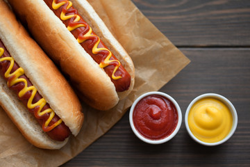 Barbecue Grilled Hot Dog with Yellow Mustard and ketchup on wooden table. Fast food.