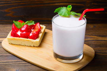 Strawberry ice cream with a cup of yogurt on a wooden background