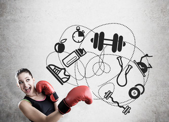 Woman boxer and sport icons on concrete wall