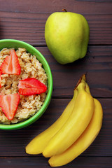 oatmeals in green plate decorated with slice of strawberry. Kiwi
