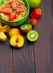 oatmeals in green plate decorated with slice of strawberry. Kiwi