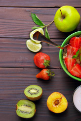 Oatmeals in green plate decorated with slice of strawberry, kiwi